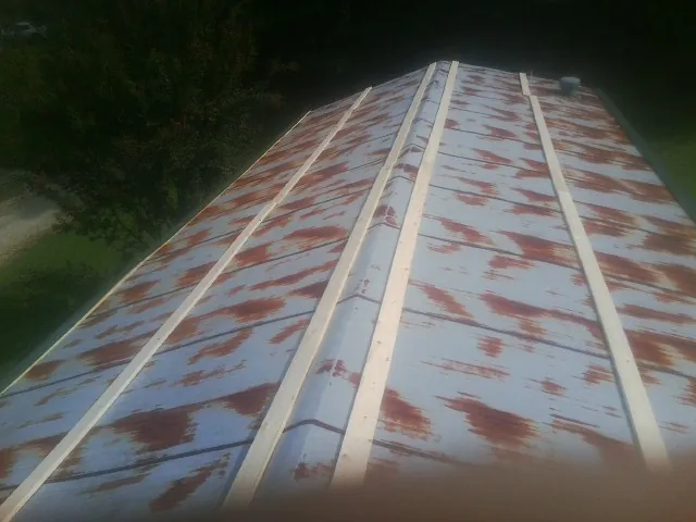 Rusted metal roof panels with new wood purlins before replacement — Storm Damage Roof Repair in Eden by Roofing Brothers